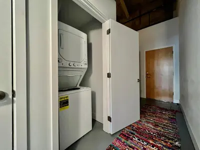 a living room with a tv and a small refrigerator at Swanky Loft Near Kings Island, Brewery, Bike Trail in Maineville