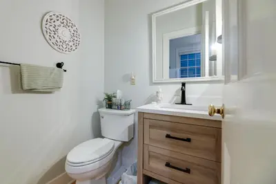 a bathroom with a toilet and a sink and a mirror at Riverfront Studio with Private Patio and Garden! in Augusta