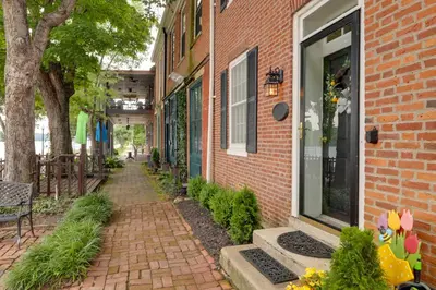 a brick building with a walkway next to a building at Riverfront Studio with Private Patio and Garden! in Augusta