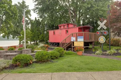a red train car on display in a garden at Riverfront Studio with Private Patio and Garden! in Augusta