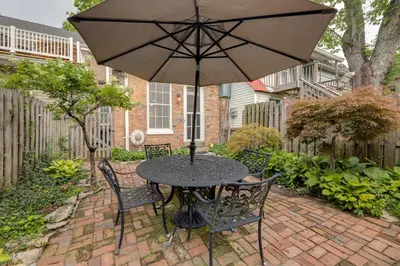 a table and chairs with an umbrella on a brick patio at Riverfront Studio with Private Patio and Garden! in Augusta