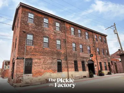 a large brick building on the corner of a street at Pickle Factory Hotel - 8BR Full Hotel with Free Parking in Covington