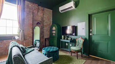 a living room with green walls and a couch at Pickle Factory Hotel - 8BR Full Hotel with Free Parking in Covington