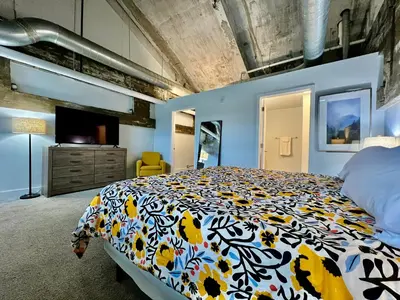 a bedroom with a large bed with a colorful blanket at New renovated Loft in Old factory by Kings Island in Maineville
