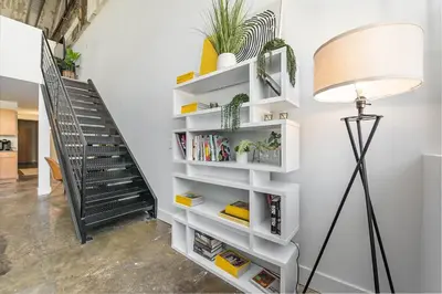 a staircase with white shelves and a lamp at The Coolest Loft in the Cincinnati Area in Maineville