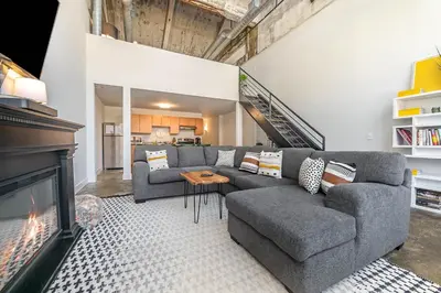 a living room with a couch and a fireplace at The Coolest Loft in the Cincinnati Area in Maineville