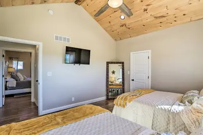 a bedroom with two beds and a flat screen tv at Chic Williamstown Retreat with Pool and Hot Tub! in Williamstown