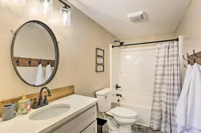 a bathroom with a sink and a toilet and a mirror at Chic Williamstown Retreat with Pool and Hot Tub! in Williamstown
