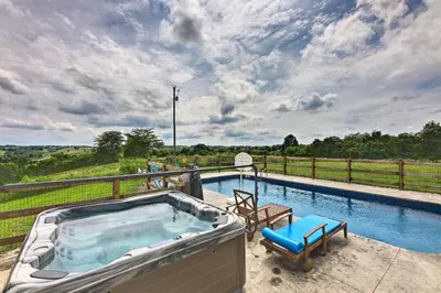 a hot tub on a patio next to a fence at Chic Williamstown Retreat with Pool and Hot Tub! in Williamstown