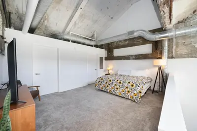 a bedroom with a bed and a tv in a room at New Industrial Loft Space on River and Bike Trail in Maineville