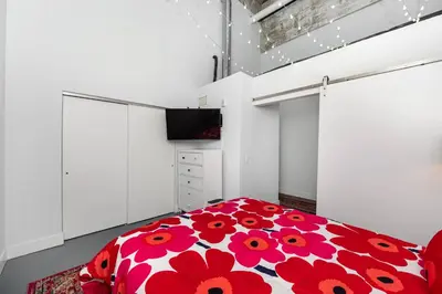 a bedroom with a red and white bed and a tv at New Industrial Loft Space on River and Bike Trail in Maineville