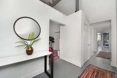 a hallway with a mirror and a table with a plant at New Industrial Loft Space on River and Bike Trail in Maineville