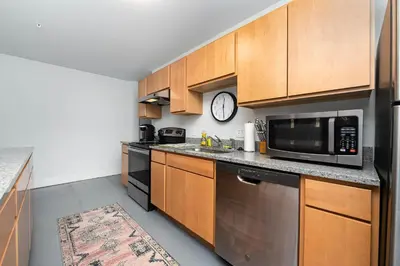 a kitchen with wooden cabinets and a microwave oven at New Industrial Loft Space on River and Bike Trail in Maineville
