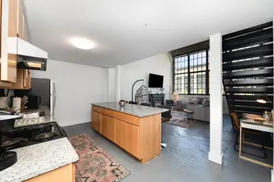 a kitchen with a counter and a living room at New Industrial Loft Space on River and Bike Trail in Maineville