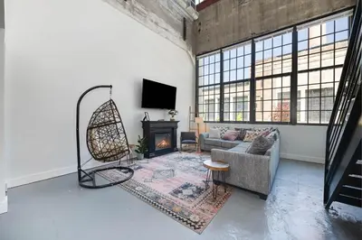 a living room with a couch and a fireplace at New Industrial Loft Space on River and Bike Trail in Maineville