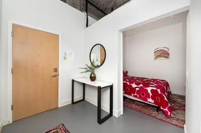 a bedroom with a bed and a mirror and a table at New Industrial Loft Space on River and Bike Trail in Maineville
