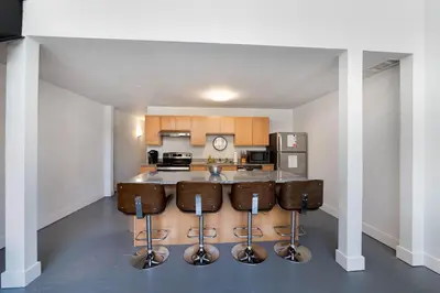 a kitchen with a bar with stools at New Industrial Loft Space on River and Bike Trail in Maineville