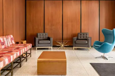a waiting room with two chairs and a table at The Orbit Hotel, Trademark Collection by Wyndham in Fairview Park
