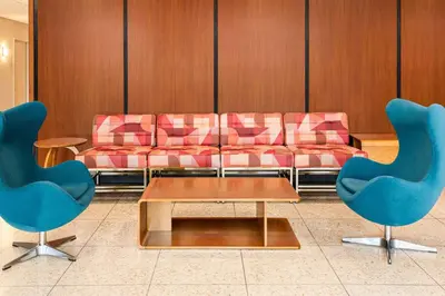 a waiting room with a couch and two chairs at The Orbit Hotel, Trademark Collection by Wyndham in Fairview Park