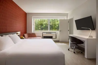 a bedroom with a bed and a desk and a computer at The Orbit Hotel, Trademark Collection by Wyndham in Fairview Park