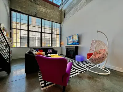 a living room with a couch and a chair at Kings Island Loft with Brewery, River, and Bike Trail in Maineville