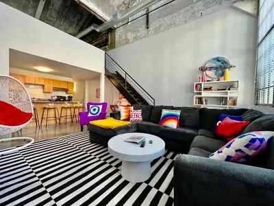 a living room with a couch and a table at Kings Island Loft with Brewery, River, and Bike Trail in Maineville