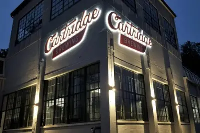 a building with neon signs on the front of it at Kings Island Loft with Brewery, River, and Bike Trail in Maineville