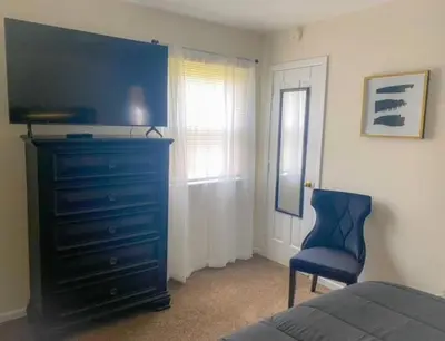 a bedroom with a blue dresser and a blue chair at Cozy Two Bedroom Apartment in the City Center in Trenton