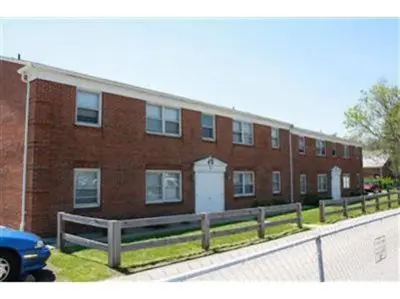 a brick building with a fence in front of it at Trenton's Apartment on First in Trenton