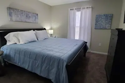 a bedroom with a bed with a blue blanket and a window at Diamond in the Rough-696 in Middletown