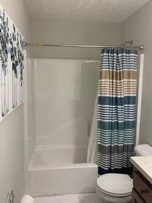 a bathroom with a shower curtain and a toilet at Diamond in the Rough-696 in Middletown