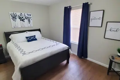 a bedroom with a bed with blue curtains and a window at Diamond in the Sky-704 in Middletown