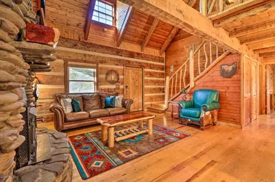 a living room with a couch and chairs in a log cabin at Luxe Dog-Friendly Cabin with Hot Tub and Game Room in Logan