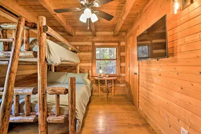 a bedroom with bunk beds in a log cabin at Luxe Dog-Friendly Cabin with Hot Tub and Game Room in Logan