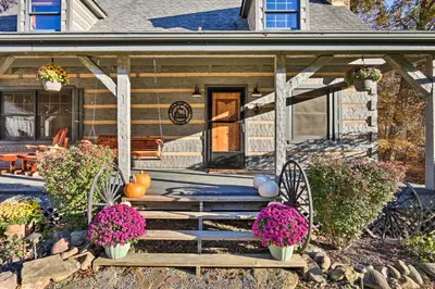 a porch of a house with pumpkins and flowers at Luxe Dog-Friendly Cabin with Hot Tub and Game Room in Logan