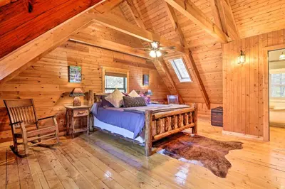 a bedroom with a bed in a log cabin at Luxe Dog-Friendly Cabin with Hot Tub and Game Room in Logan