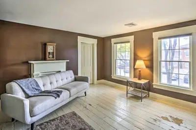 a living room with a couch and two windows at Historic Troy Home Close to Shops with Fire Pit in Troy