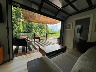 a living room with a couch and a view of a deck at The Hideaway on Tacketts - Shipping Container in Hurricane