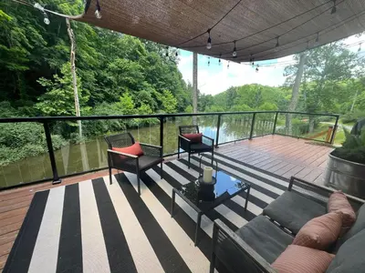 a screened in deck with two chairs and a couch at The Hideaway on Tacketts - Shipping Container in Hurricane