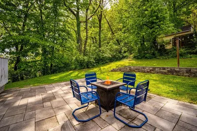 a patio with a table with chairs and a fire at Cozy Cottage in the Heart of Hyde Park home in Cincinnati