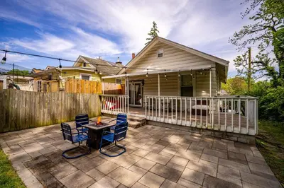 a patio with chairs and a table in front of a house at Cozy Cottage in the Heart of Hyde Park home in Cincinnati