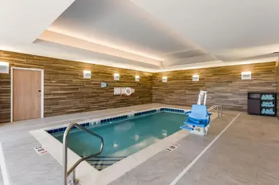 a swimming pool with a blue chair and a basketball hoop at Fairfield by Marriott Inn & Suites Columbus Canal Winchester in Canal Winchester