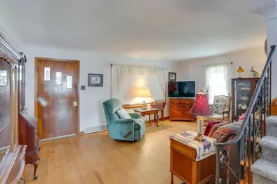 a living room with a blue chair and a couch at Home with Screened-In Porch Less Than 1 Mi to Lake Erie in Port Clinton