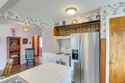 a kitchen with a white refrigerator and a table at Home with Screened-In Porch Less Than 1 Mi to Lake Erie in Port Clinton