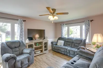 a living room with couches and a flat screen tv at Home with Screened-In Porch Less Than 1 Mi to Lake Erie in Port Clinton