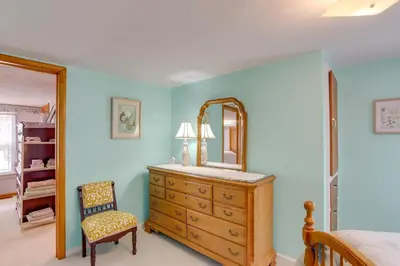 a bedroom with a dresser with a mirror and a chair at Home with Screened-In Porch Less Than 1 Mi to Lake Erie in Port Clinton