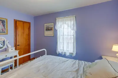 a blue bedroom with a bed and a window at Home with Screened-In Porch Less Than 1 Mi to Lake Erie in Port Clinton