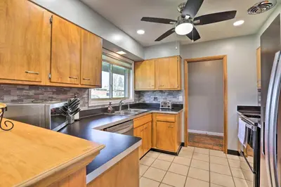 a kitchen with wooden cabinets and a ceiling fan at Dayton Home with Patio and Fire Pit about 6 Mi Dtwn! in Dayton