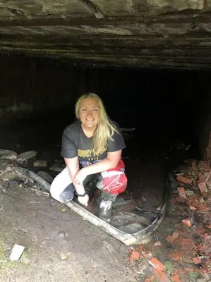 a woman is sitting in a dark cave at Sheppard's Holler in Parsley