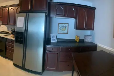 a kitchen with a stainless steel refrigerator and wooden cabinets at Spacious Four Bedroom Attached Home in Springboro- Unit 1 in Springboro